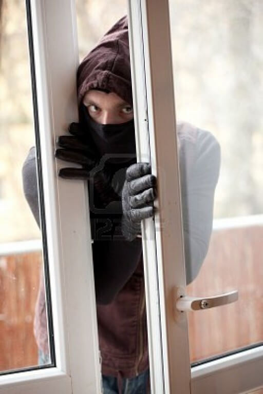 9331436 ladron en la mascara y hood irrumpir en una casa a traves de la ventana 512x768